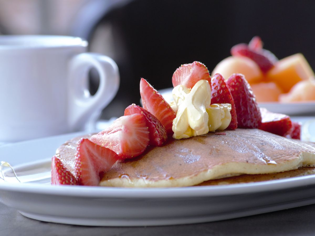 Desayuno de La Siesta: hotcakes con fresas y café