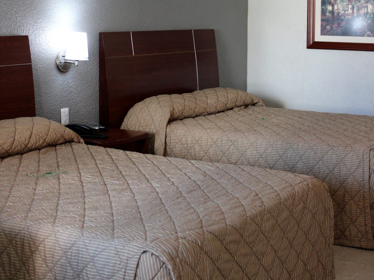 Habitación doble clásica: dos camas con cabecera de madera y lámparas de pared