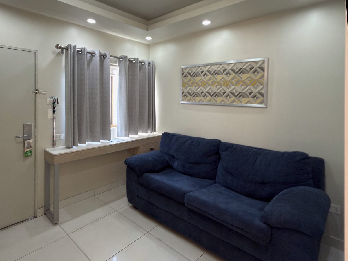 Junior Suite living area: blue sofa by the window and the front door