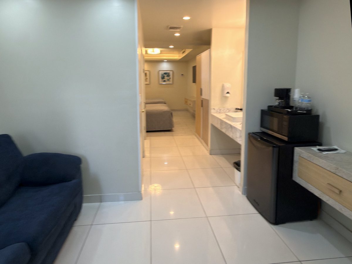 Junior Suite seen from the living area toward the bedroom, with the kitchenette to one side