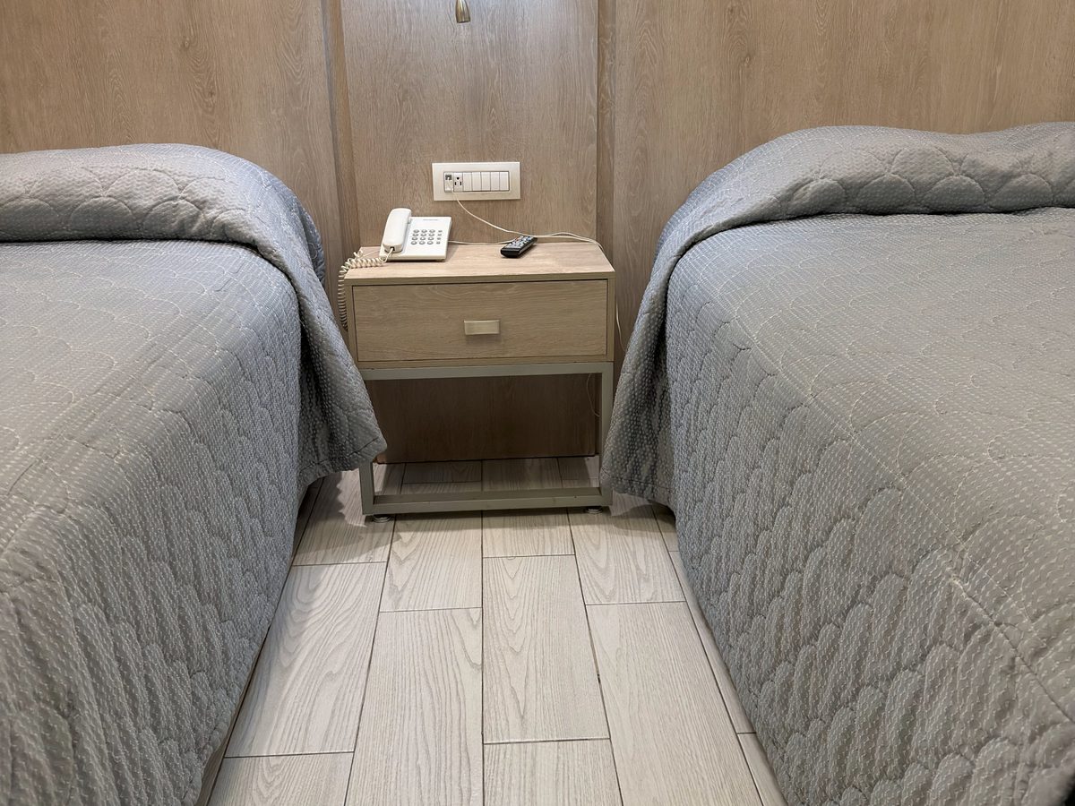 Nightstand with phone between the two beds of the Junior Suite