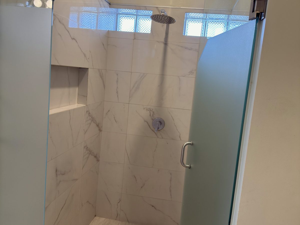 Junior Suite shower with glass door and marble walls