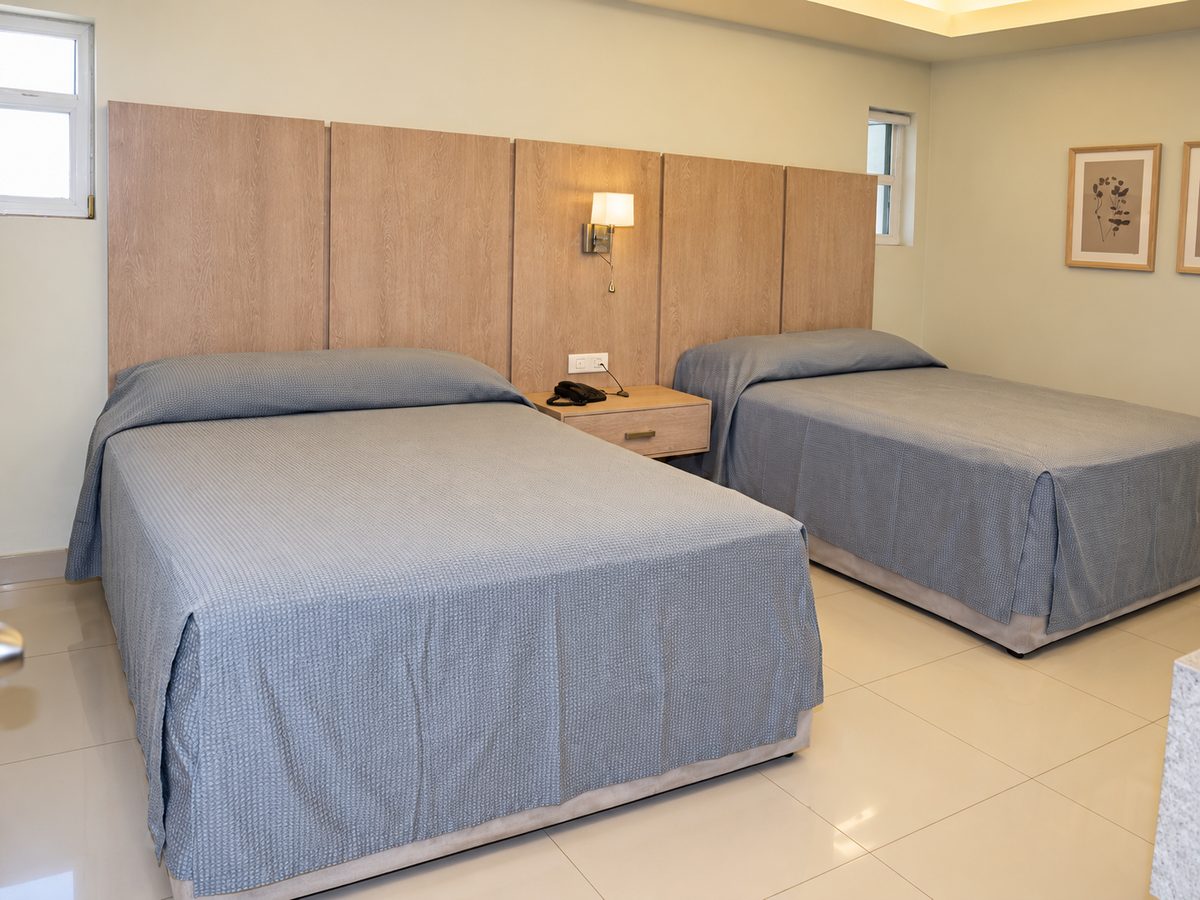 Recámara de la Master Suite: cama King y cama matrimonial con cabecera de madera clara